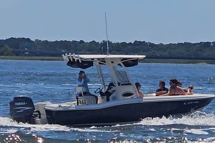 Small motorboat with people on a sunny day in open water.