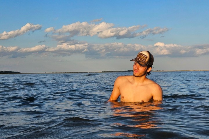 a man standing next to a body of water