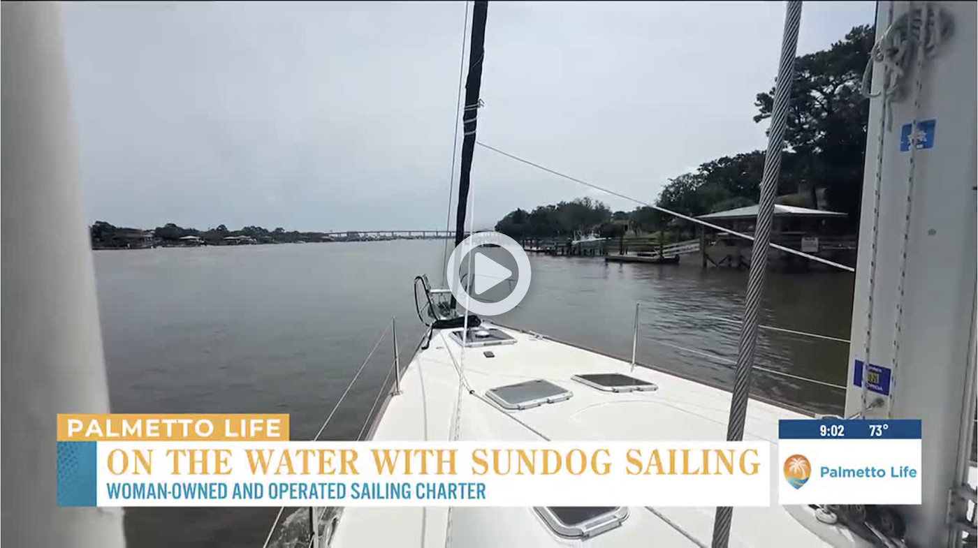 Bow of a sailboat on a river; TV overlay about a sailing charter.